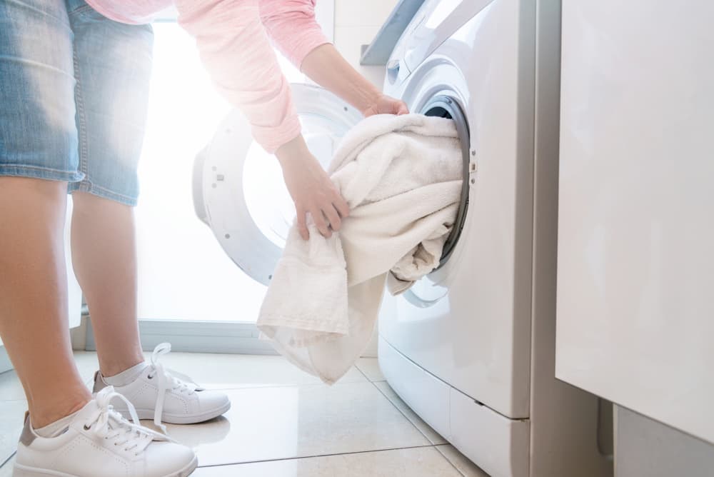 woman taking towels out of an electric dryer